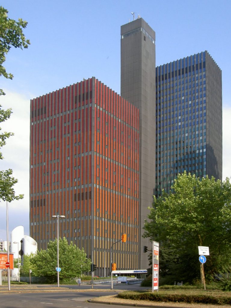 Das Funkhaus der Deutschen Welle. Links der rote Studioturm, rechts der blau-türkise Büroturm und in der Mitte der Aufzugsturm. Bild: Riadismat